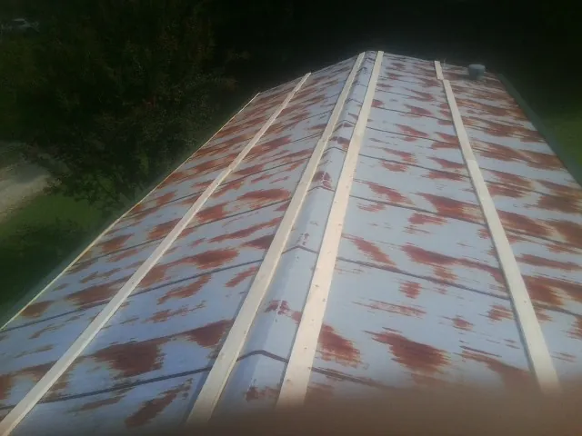 Rusted metal roof panels with new wood purlins before replacement — Storm Damage Roof Repair in Baxter by Roofing Brothers
