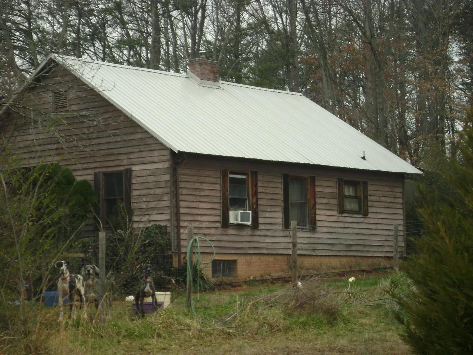 White metal roof on an old wood sided farmhouse, from a Metal Roof Installation job in Baxter